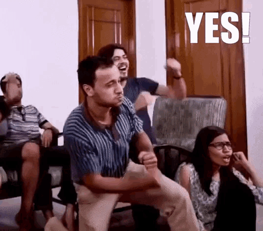 a group of people are sitting on a couch and one of them is making a yes sign .