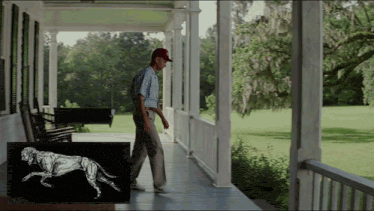 a man walking on a porch next to a painting of a horse