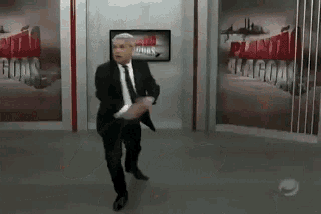 a man in a suit and tie is jumping in the air in front of a wall that has the word lagos on it