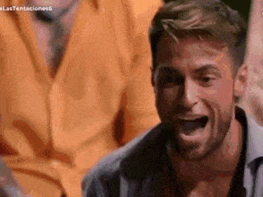 a man with a beard is laughing with his mouth wide open .