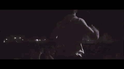 a man is standing on a stage in front of a crowd of people .