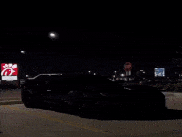 a black corvette is parked in a parking lot