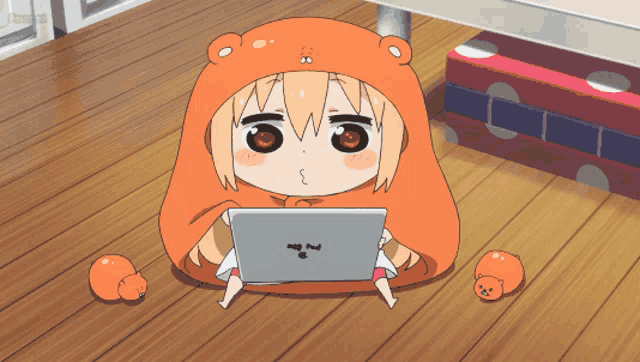 a girl in a bear hood is sitting on the floor with a laptop