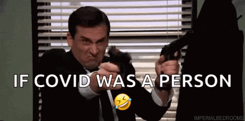a man in a suit and tie is pointing a gun at another man and says if covid was a person .