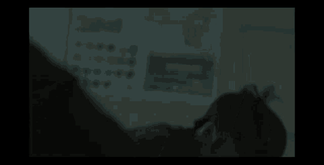 a man is laying down in a dark room in front of a calendar .