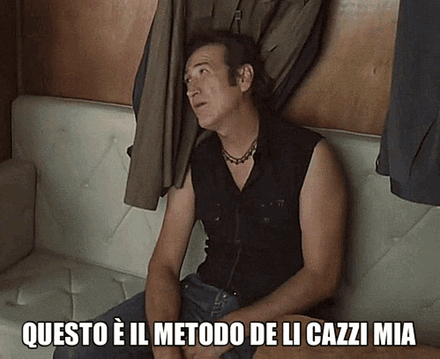 a man sitting on a couch with the words " questo e il metodo de li cazzi mia " on the bottom