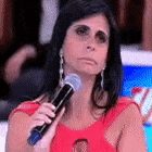 a woman in a red dress is holding a microphone in front of her face .