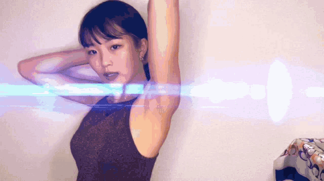 a woman in a brown tank top with her arms up