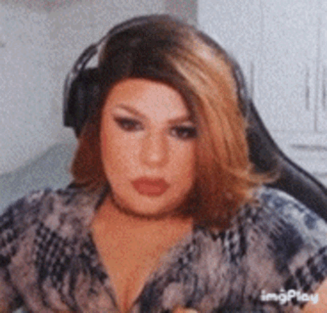 a woman wearing headphones and a choker is sitting in a chair .