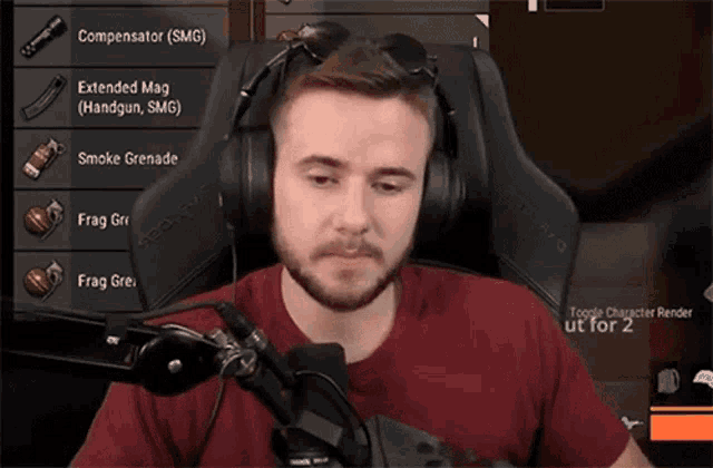 a man wearing headphones and a red shirt is playing a video game