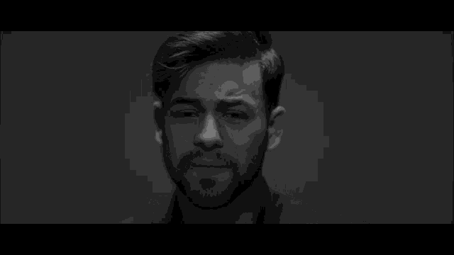 a black and white photo of a man with a beard and his eyes closed