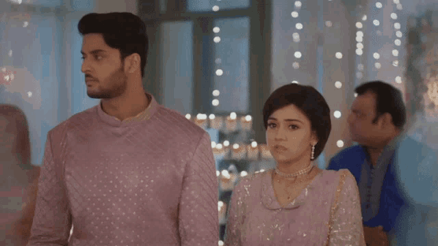 a man and a woman are standing next to each other holding hands