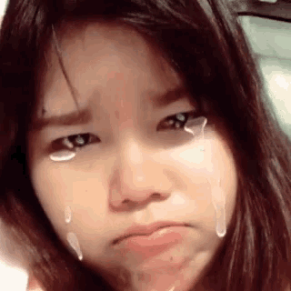 a girl with tears running down her face is making a sad face