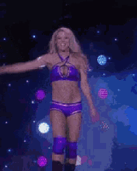 a woman in a purple bikini is dancing in a dark room