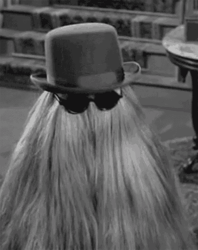a black and white photo of a woman wearing a hat and sunglasses .