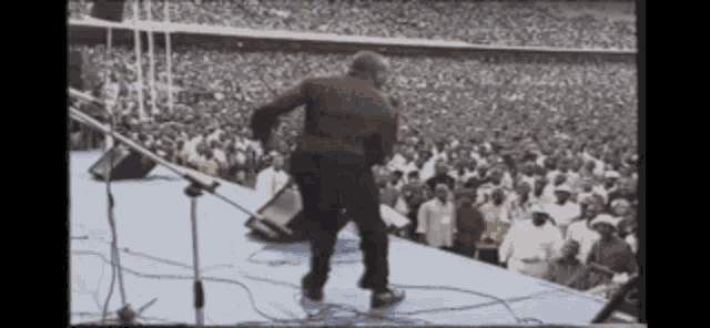 a man standing on a stage in front of a crowd