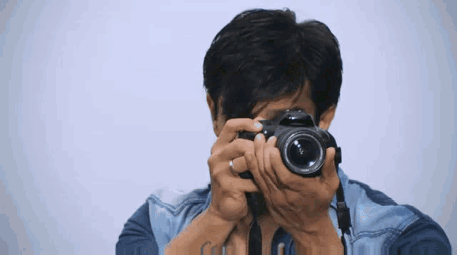 a man is taking a picture with a canon brand camera