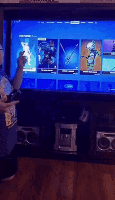 a man is playing a video game on a large flat screen television