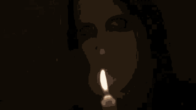 a woman with glowing eyes is holding a candle in her hand .