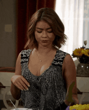 a woman in a paisley top is holding a knife and fork in her hand