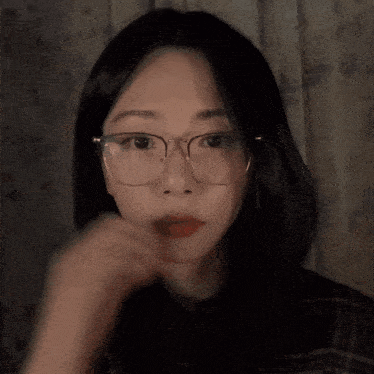 a woman wearing glasses is looking at the camera