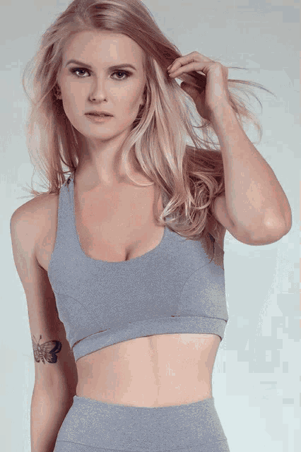 a blonde woman with a tattoo of a butterfly on her arm