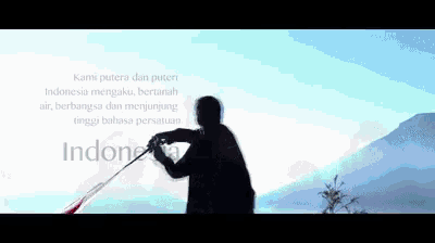 a man is holding a flag in front of a mountain and a blue sky .