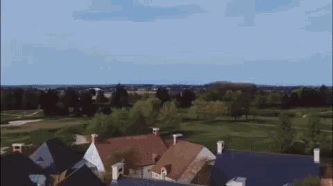 an aerial view of a residential area with houses and a golf course in the background