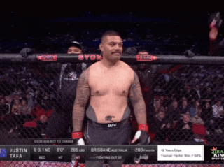 a fighter named justin tafa is standing in front of a fence