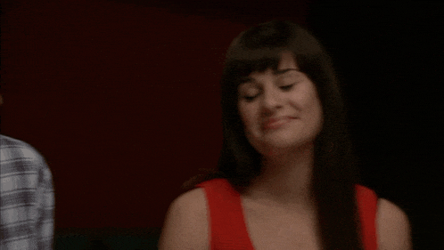 a woman in a red tank top is smiling