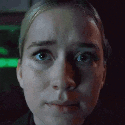 a close up of a woman 's face with a green light behind her