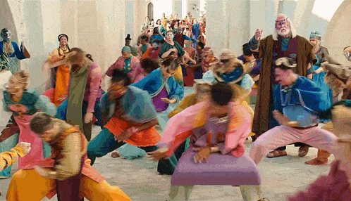 a group of people in colorful costumes are dancing in a room