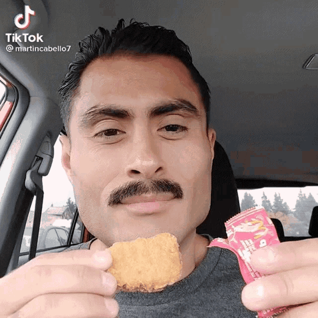 a man with a mustache is eating a chicken nugget from mcdonald 's