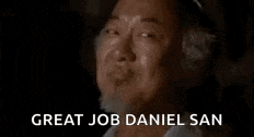 a man with a beard is smiling with the words `` great job daniel san '' written below him .