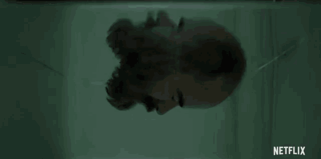 a man with a beard is looking at himself in a mirror with netflix written in the corner