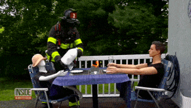 a fireman with the number 1 on his helmet is serving a woman at a table