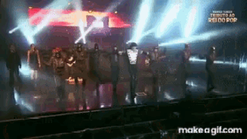 a group of people dancing on a stage with the words make a gif.com in the bottom right corner