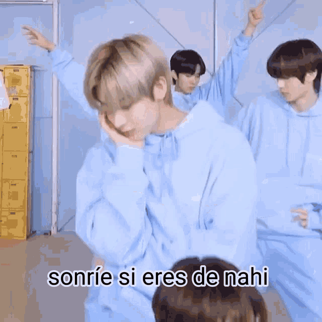 a group of young men in blue sweatshirts are dancing together .