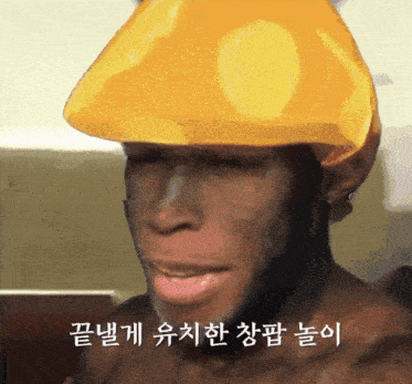 a man wearing a yellow hat with korean writing on the bottom