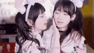 two girls are kissing each other in a room .