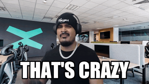 a man wearing headphones and a beanie says " that 's crazy "
