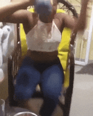 a woman is sitting in a chair with her arms up