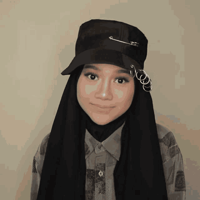 a woman wearing a hijab and a hat with rings around her ears