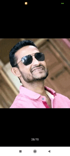 a man wearing sunglasses and a pink shirt with the date 28/70