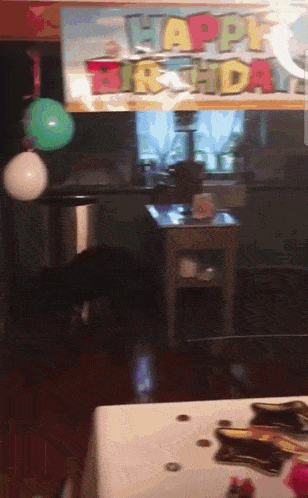 a room with balloons and a sign that says ' happy birthday '