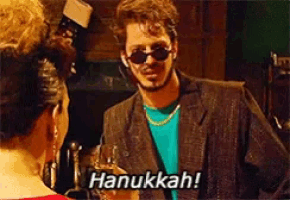 a man wearing sunglasses is holding a glass and says hanukkah