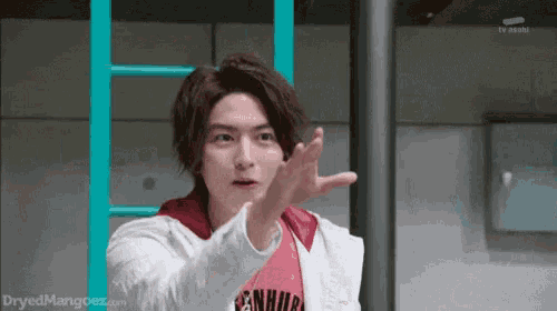 a young man is making a funny face while holding his hand up .