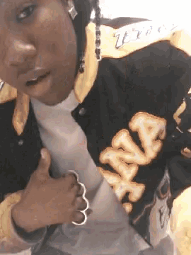 a woman wearing a black and yellow jacket with the word wiz on the sleeve