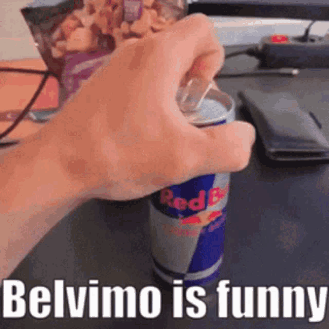 a person is opening a can of red bull with a bag of cereal in the background .