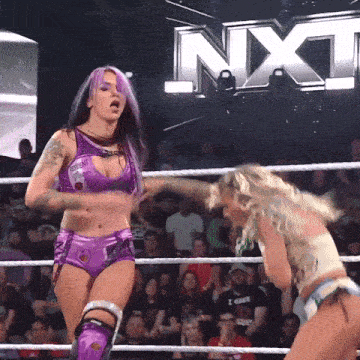 two women are wrestling in a ring with nxt written on the back